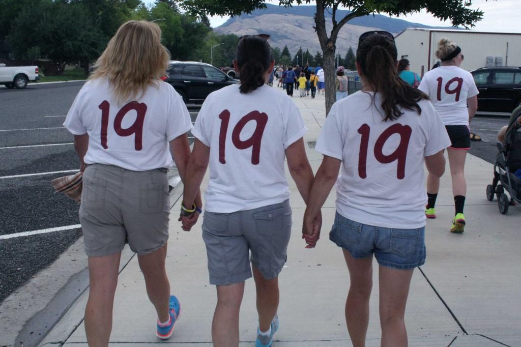 Three sisters, (left to right) Lisa ODell, Angela Brennan, and Kerry Dunlavy, walk to represent their team, 4Jutst 19, at the Out of the Darkness Walk on Sep. 7, 2013. 