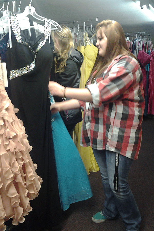 Junior Jillian Rhodes sorts through dresses as part of the pre Prom fashion show