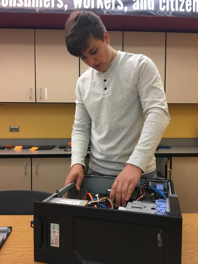 Ben Osmun repairs a computer for the school district technology department. (Photo Caleb Keller)