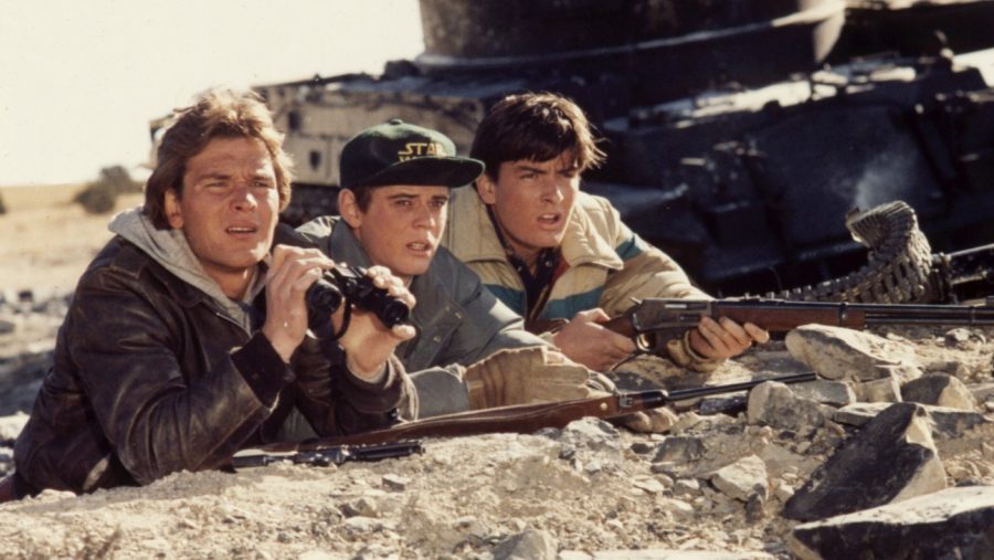 Matt, played by Charlie Sheen, and Jed, played by Patrick Swayze watch the enemy from afar.
